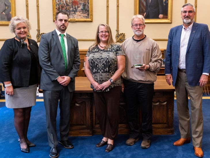 A photo showing five people at the Indiana Governor's Award for Environmental Excellence ceremony. Pictured are Julia Wickard, Brian Rockensuess, Jeanette Pope, Chris Hoffa, and Eric Holcomb