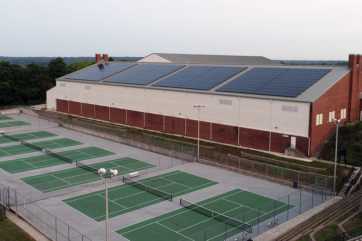 Photo showing rooftop solar panels on DePauw University's Indoor Track and Tennis Center, representing SunPeak's capabilities as a commercial solar installation company.