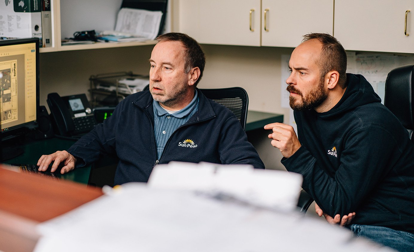 Two SunPeak workers reviewing the computer screen