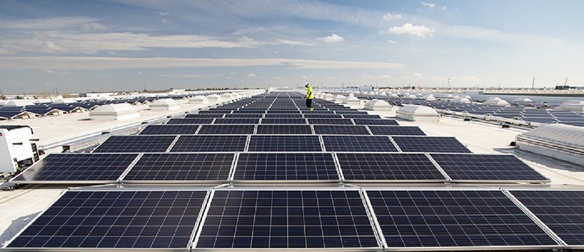 A solar panel installation engineer on a large rooftop of solar panels, representing how to achieve company ESG goals with solar.